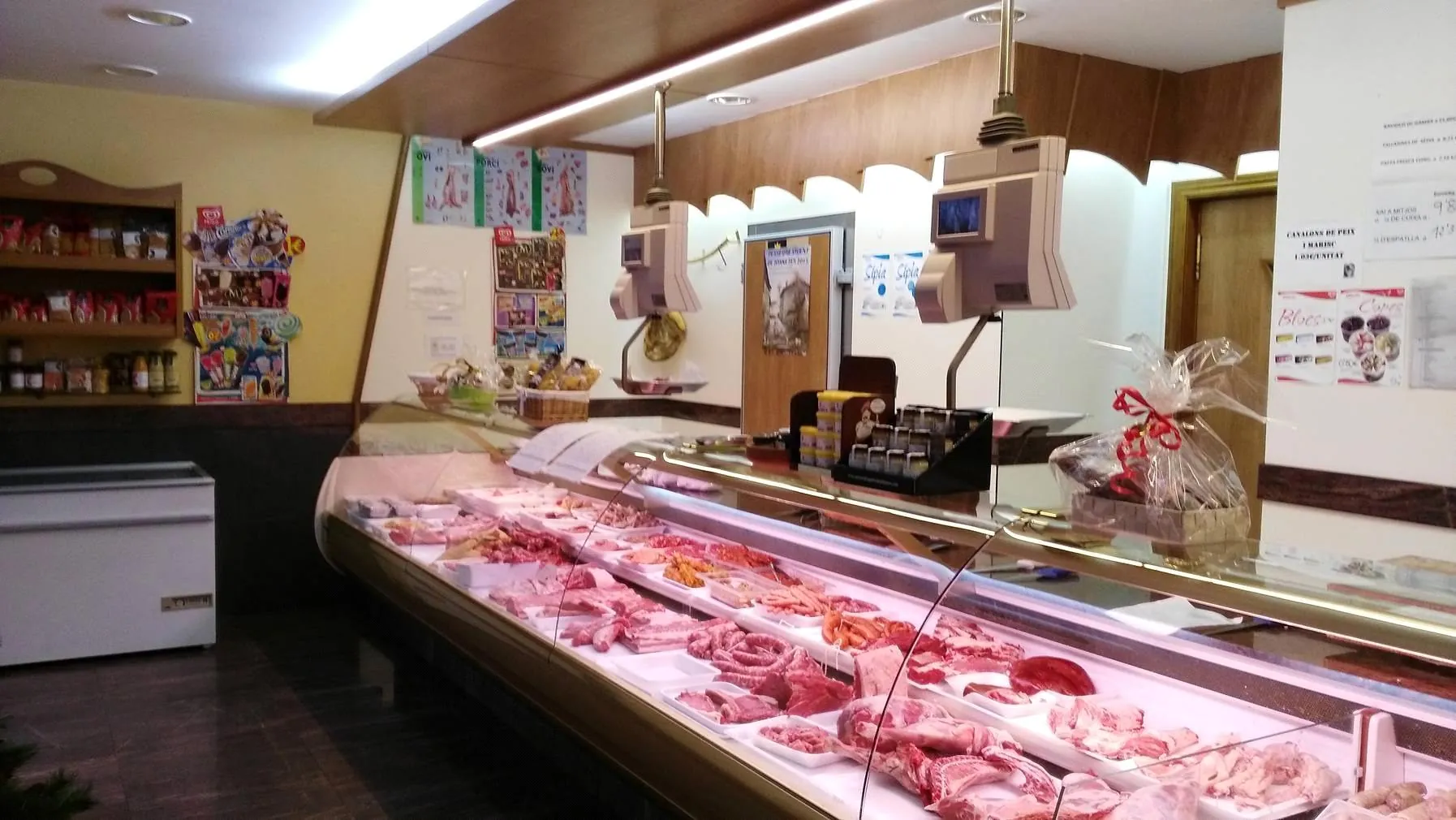 Interior de la carnicería con el mostrador refrigerado lleno de género